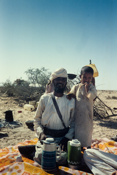 Father and son serving tea, coffee and dates