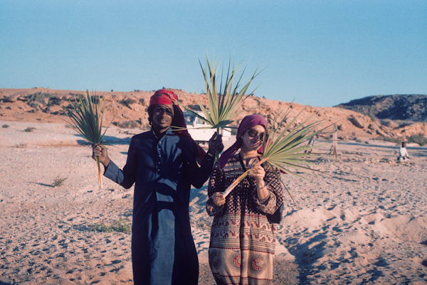 Holding dwarf palm fronds at Wadi Baw well