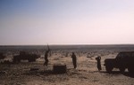 Men preparing for trip across the desert with rifle